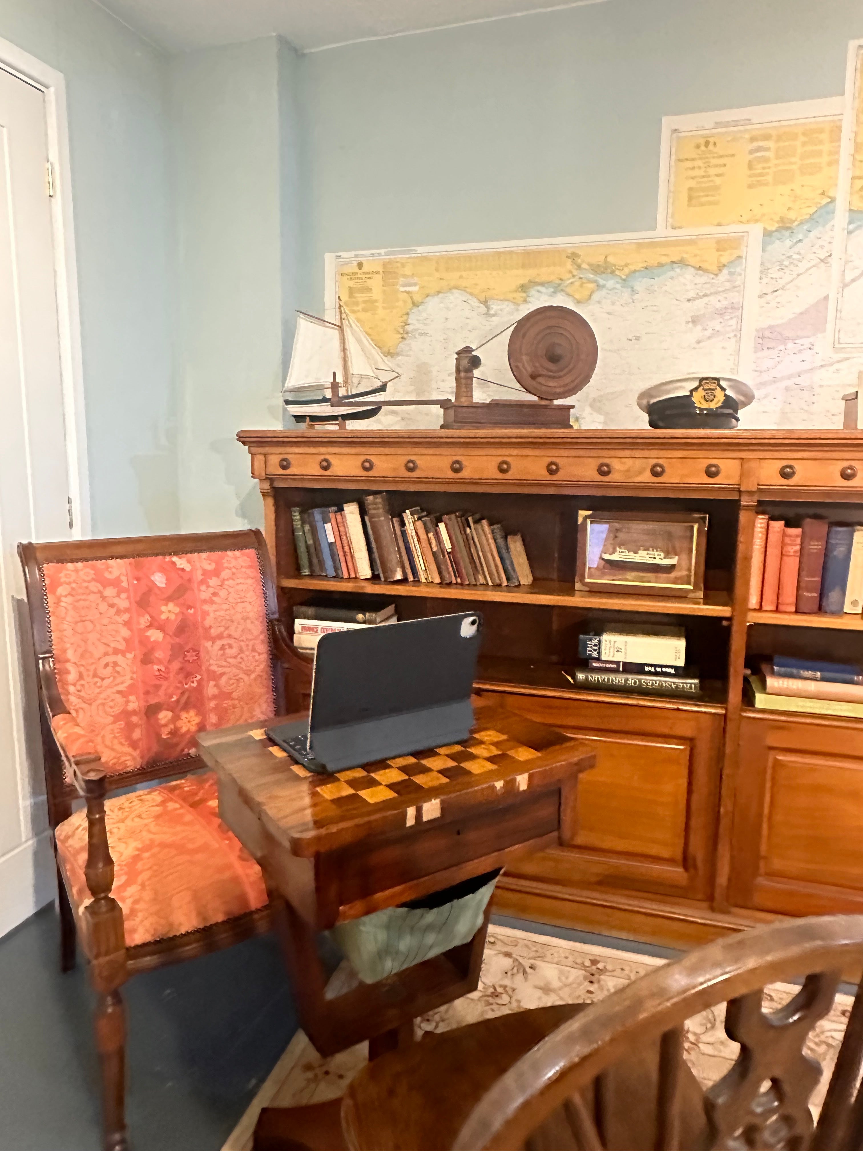 iPad on a chess table with a chair and dresser in a room setting